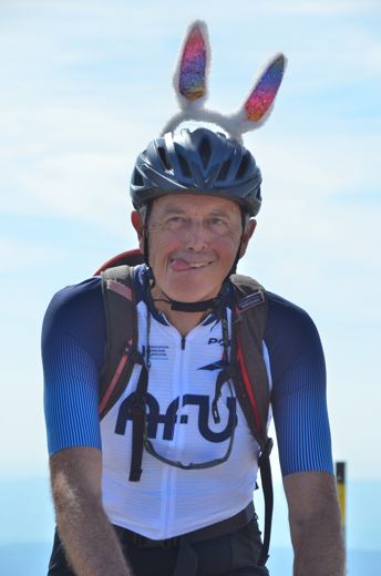Un cycliste souriant avec un casque décoré.